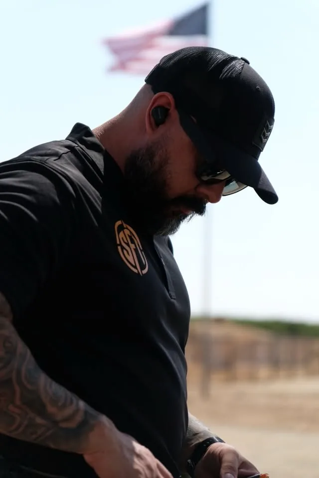 Silverline firearms instructor in a Silverline Firearms Training polo, checking the line during a range session.